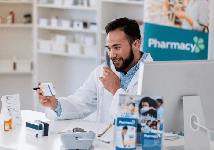 Pharmacist on telephone dispensing advice and medication