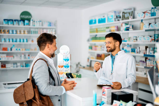 Male pharmacist helping a customer.